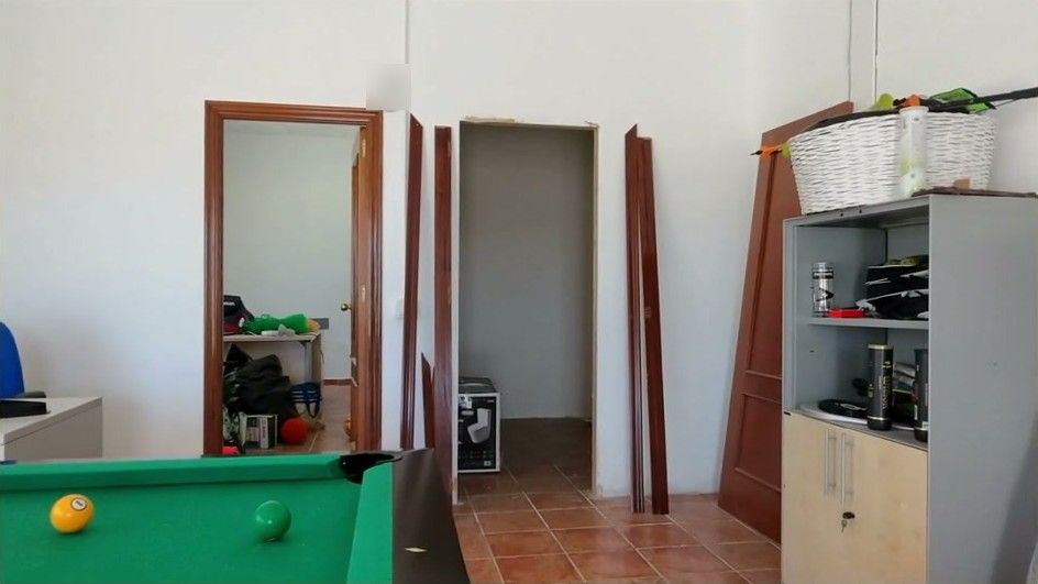 Una sala de paso con una mesa de billar y muebles guardados